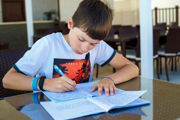 Fototapeta na wymiar Preteen schoolboy doing his homework. Education and distance learning for kids. Homeschooling during quarantine. Stay at home entertainment.