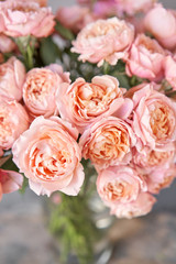 Flower shop delivery concept. Roses of multicolor, pastel pink and pale orange color. Lots of buds. Floral natural background