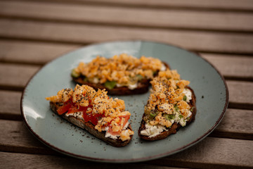 Avocado toasts with scrambled eggs, feta cheese and tomatoes