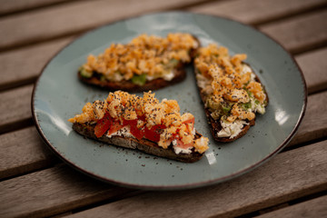 Avocado toasts with scrambled eggs, feta cheese and tomatoes