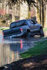 a flooded park with a pickup truck driving through © Taya