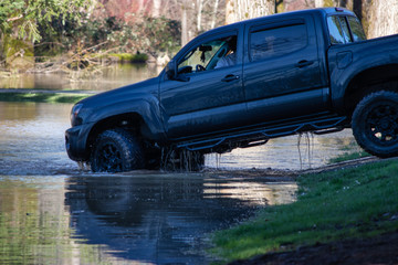 backing a black pickup truck out of a flood