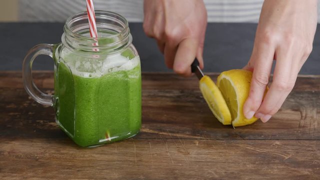 Woman decorating jar of healthy green smoothie