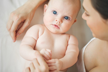 Woman with a baby on a white background. Mom holds the baby. 