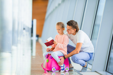 Happy family with two kids in airport have fun waiting for boarding
