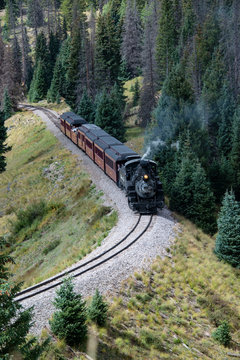 Historic Cumbres Toltec narrow-gauge train engine chugging up the mountain going north to Antonito, Colorado railroad station