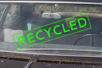 A stamp sign recycled on a part of an old rusty abandoned car, vehicle, environmental protection and metal reuse concept