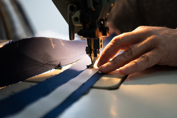 A man sews yacht accessories on a sewing machine. Close-up.