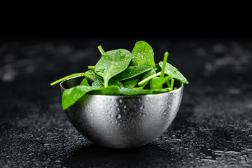 Fresh Spinach on a dark slate slab (close-up shot)