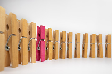 Clothespins simulating a woman standing out in a row of people.