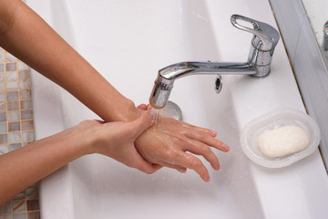 The girl brought the burn place under a stream of water for first aid