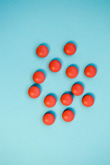 Red round medical pharmaceutical pharmaceuticals for the treatment of diseases pills medicines on a blue background