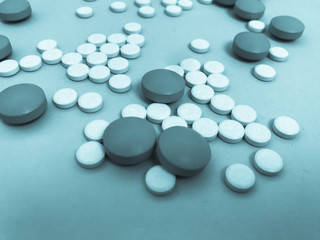 Round medical pharmaceutical medicines for the treatment of diseases and the killing of microbes and viruses pills and vitamins medicines for coronavirus gray on a blue background