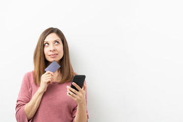 Woman thinking what to buy with credit card