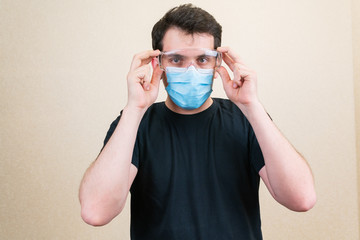 Young man in protective medical mask and glasses. Self-isolation and quarantine. Stay home