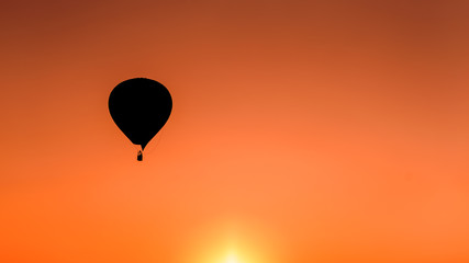 Silhouette  hot air balloon over mountains in sunset sky