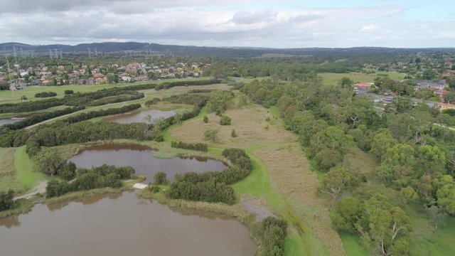 Flight over natural pools and park towards residential area in Rowville, Australia