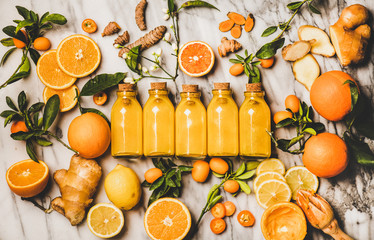 Immune boosting vitamin health defending drink. Flat-lay of fresh turmeric, ginger, citrus juice...