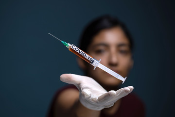 syringe coronavirus vaccine on blue background