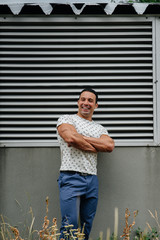 Fototapeta premium A sporty guy stands near a gray wall. Lifestyle