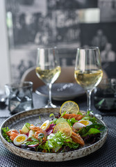 Fresh green salad with smoked trout, eggs and herbs