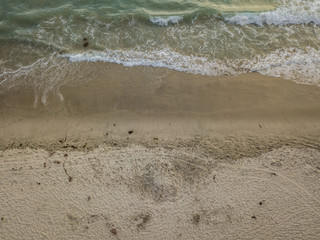 aerial view of waves crashing on the beach
