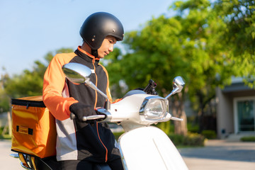 Asian man courier checking customer location in map in smartphone on scooter delivering food in...