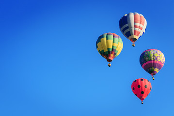 Colorful hot-air balloons flying in blue sky