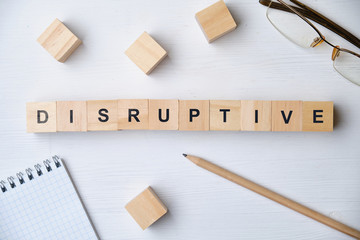 Modern business buzzword - disruptive. Top view on wooden table with blocks. Top view.