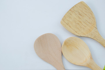 Three styles of wooden spoons on white floor