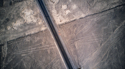 Aerial top-down view on "the Lizard" one of the Nazca lines. Mysterious lines and geoglyphs cut in half due to pan American highway