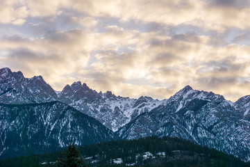 close-up view of the mountain peak with trees and snow on it sunset time.