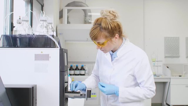 Scientist taking cbd samples from chromatography machine in laboratory