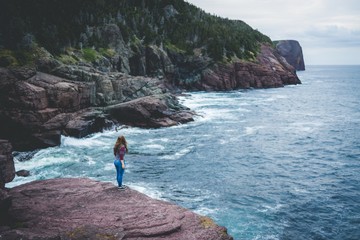 young woman walking on the beach cliff