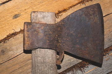 Rusty axe hangs on wooden wall. hand instrument. working tool