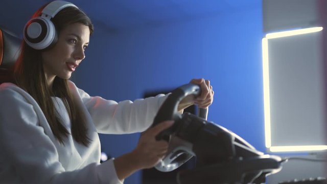 The gamer girl playing video games with steering wheel
