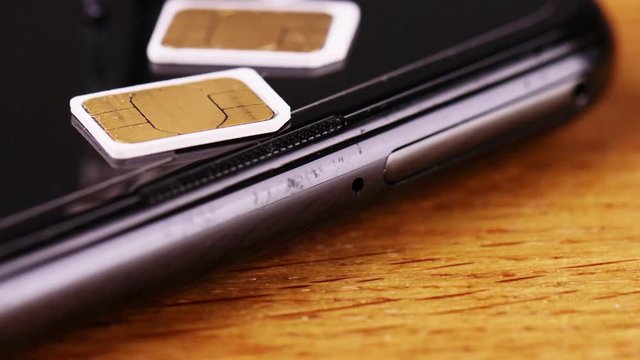 スマートフォンのSIMカードについて説明するビジネスマン　チルトダウン