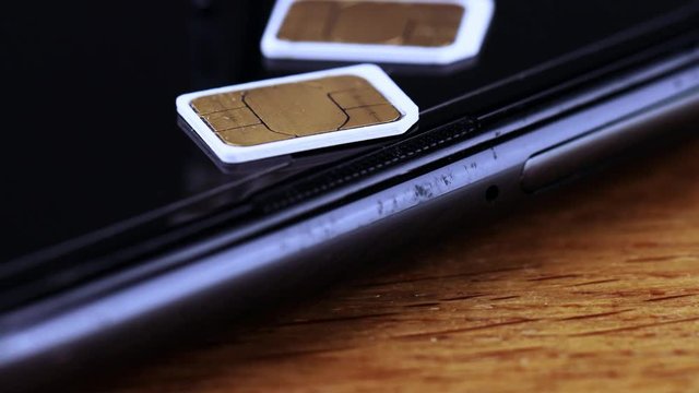 スマートフォンのSIMカードについて説明するビジネスマン　チルトダウン