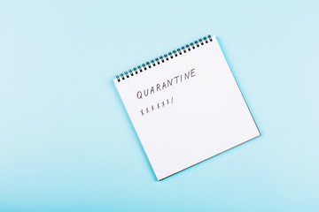Open notebook on blue paper background, flat lay, top view. Counting days of quarantine during coronavirus covid-19 outbreak. Stay at home during pandemic, self isolation concept. Overhead