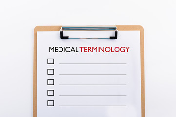 "MEDICAL TERMINOLOGY" concept. Note pad and white paper on white background