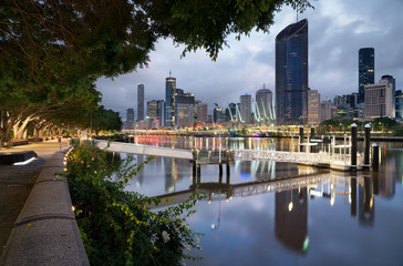 South bank Brisbane river boardwalk at sunrise with the city cat pier dock and city background