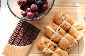 Hot cross buns with cherry and dark chocolate for decoration.