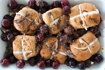 Hot cross buns with cherry and dark chocolate for decoration.