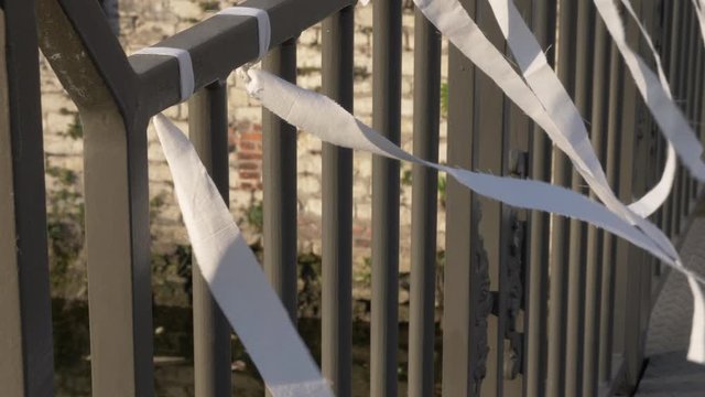 Close up of white ribbons hanging on a handrail, slow motion