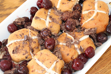 Hot cross buns with cherry and dark chocolate for decoration.