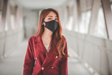 Asian woman wearing mask for protect pm2.5 and cough with Covid-19 virus outbreak in public.