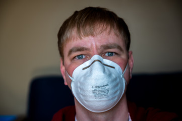 front view of middle aged white Caucasian male with blonde hair wearing a N95 protective mask