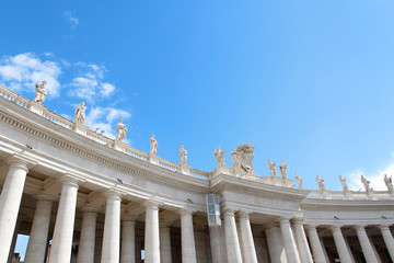 A group of Saint Statues on the colonnades of St Peter's Square with blue sky and clouds in Vatican City, Rome, Italy