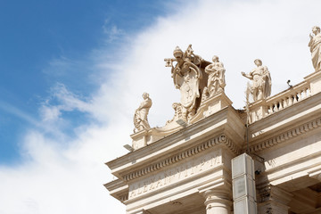 A group of Saint Statues on the colonnades of St Peter's Square with blue sky and clouds in Vatican...