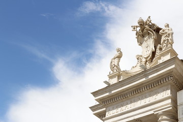 St. Agnes and St. Catherine on the colonnades of St Peter's Square with blue sky and clouds in Vatican City, Rome, Italy